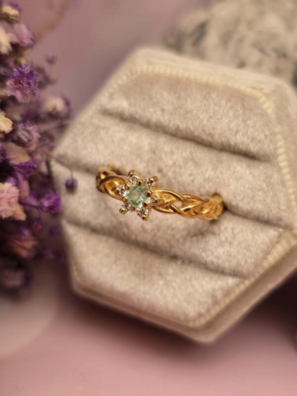 Anillo trenzado en plata con Flor en Esmeralda Colombiana y circones con baño en oro 18K